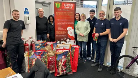 Revive Centre Charity A group of volunteers stood up with bags of presents at their feet