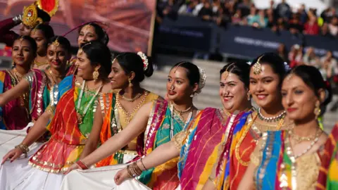 PA Media dancers hold up their multi-colored saris in a line during the celebration of Diwali on the Square