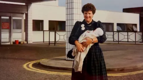 Family picture Ms Harris's mother holding her as a baby outside the hospital. Photo taken in 1989.