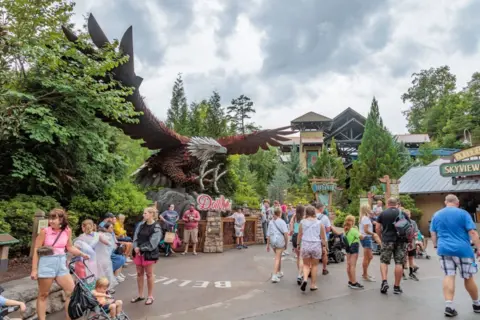 Getty Images A large statue of an eagle with spread wings is in the midst of a theme park swarming with visitors