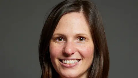 Parliament The official Westminster portrait of Sarah Smith MP. She is smiling and has long brown hair and brown eyes