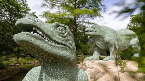 Iguanodon dinosaur with another green dinosaur in the background 