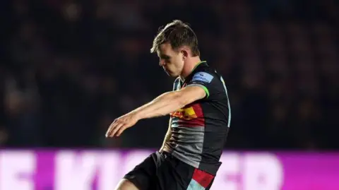 Harlequins fly-half Jamie Benson kicks the ball off a tee with his head down