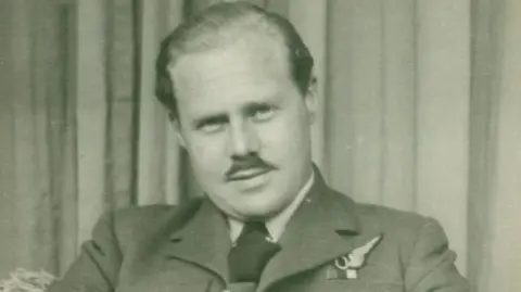 Stuart Green A young Alan Green looks at the camera, dressed in his RAF uniform. His hair is smartly combed back, and he sports a moustache.