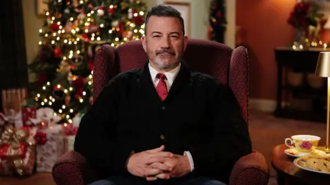 Channel 4 Jimmy Kimmel sitting in front of a Christmas tree as he delivers Channel 4's alternative Christmas message