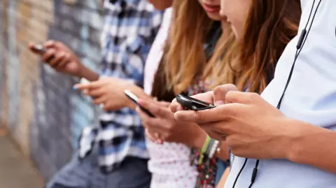General shot of teenagers on their phones