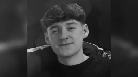 Family picture Bailey Chadwick in a black and white picture is smiling at the camera and has dark hair