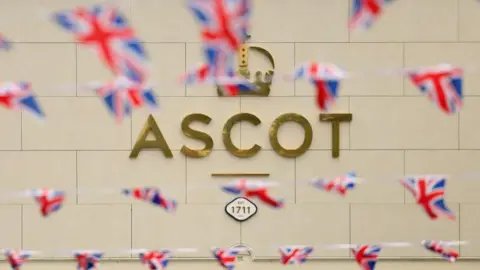 Getty Images The word Ascot is written in gold with union jack flags in the foreground. 