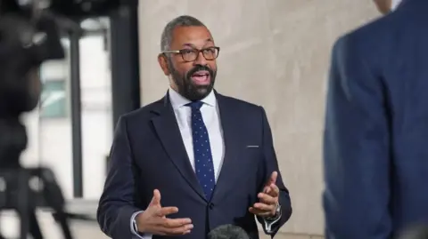 James Cleverly speaks to the media