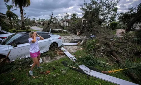 Bill Ingram/Palm Beach Post via REUTERS Marie Cook reacts to the damage to her home in the Binks Estates community after a tornado formed by Hurricane Milton touched down striking homes in The Preserve and Binks Estate among others in its path in Wellington, Florida, U.S. October 9, 2024. 