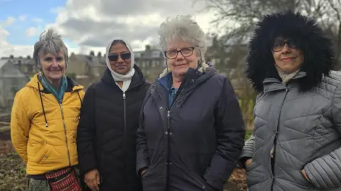 Aisha Iqbal/BBC A group of four ladies standing in an allotment.