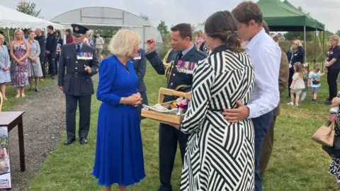 The Queen being shown round the Wellness Garden 