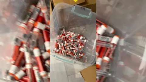 Looking down into a clear bucket of orange weigh-loss jabs.