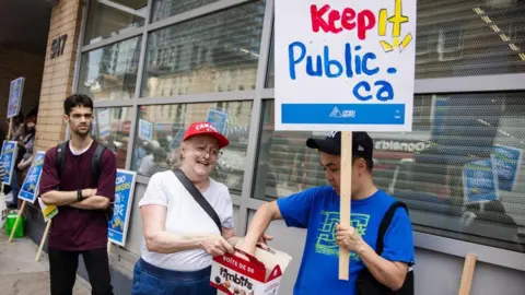 Toronto Star via Getty Images  Cindy Wray who has worked at the LCBO for 13 years hands out timbits to people on the picket line.