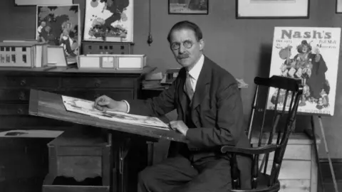 Artist and cartoonist William Heath Robinson (1872 - 1944) at his drawing board. 