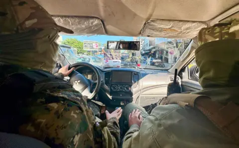 Quentin Sommerville / BBC HTS drive through the busy streets of Latakia