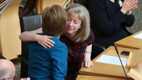 PA Media Sturgeon hugs Robison in the Holyrood chamber