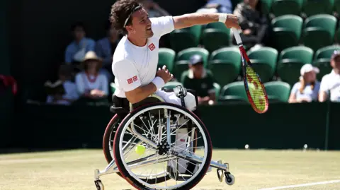 Wheelchair tennis player Gordon Reid returns a shot