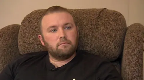 BBC Jason Knight sat in an armchair