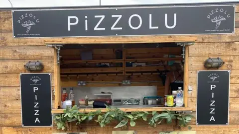 STEFFAN CORBINZOLU Pizza food truck with shutter open exposing mobile kitchen