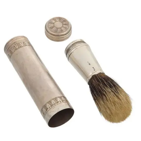 PA Media A silver cylinder with a lid and a silver shaving brush.