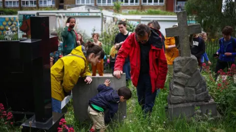 Getty Images A small group of people are shown how to forage in Tower Hamlets Cemetery Park