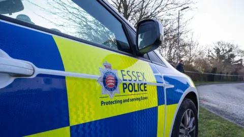 Essex Police branded police car parked on the side of a road 