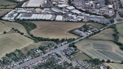 Google Earth A satellite view of fields off the A5, on the outskirts of Hinckley, with an industrial estate at the top of the image and a housing estate at the bottom of the image.