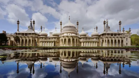 Getty Images Brighton Royal Pavilion, with its numerous domes and minarets, reflected onto a lake