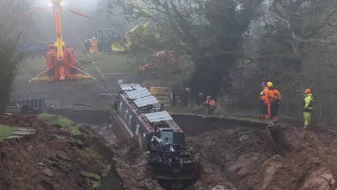 EPA/Shutterstock Stranded boats set for recovery after canal collapse in Whitchurch,