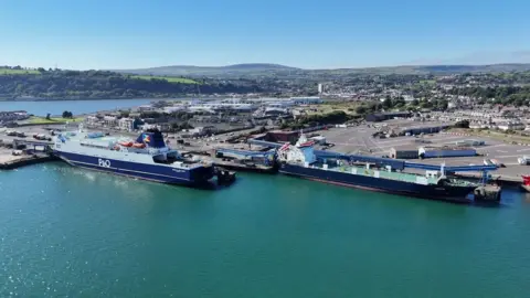 A drone image of two ships parked in Larne Harbour. One ship says P&O and the other is a cargo ship waiting to be loaded.