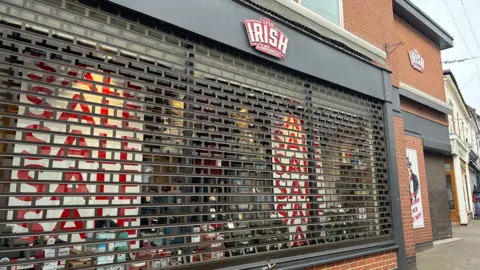 The shuttered front of Irish Menswear in Loughborough