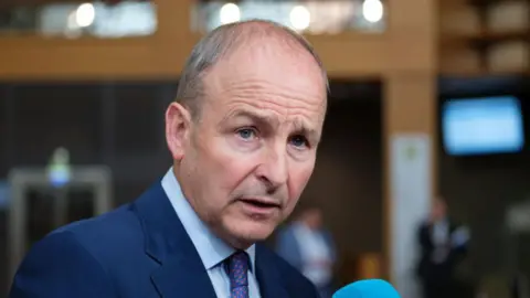 Getty Images Micheal Martin usa un traje azul marino y una camisa azul 