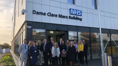 East Suffolk and North Essex NHS Foundation Trust Men and woman standing outside the new Essex and Suffolk Elective Orthopaedic Centre