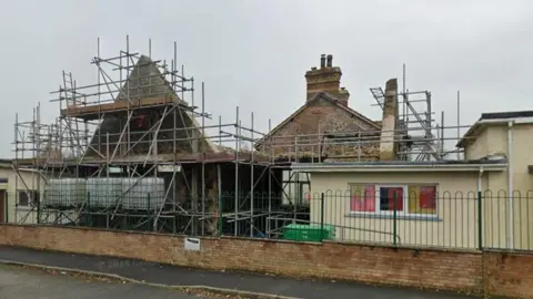 Manorbier School. It has no roof in places and is covered in scaffolding 