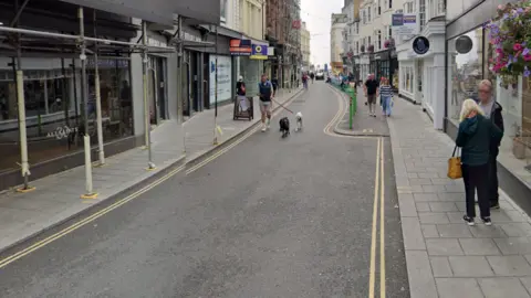 Google A google street view picture of East Street, a narrow road with shops all the way down on either side.