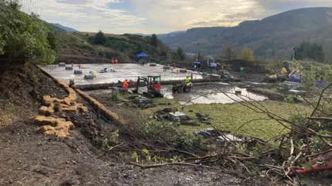 Repair work underway at Tynywaun treatment works - top soil is removed from large drinking water tanks by diggers.