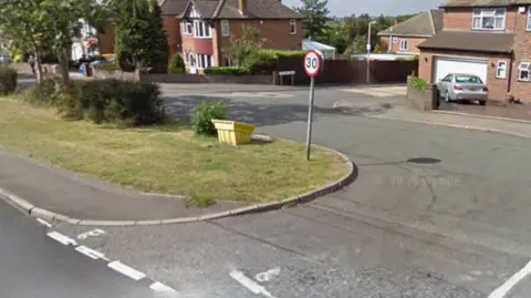 Uppingham Road at the junction with Anthony Drive. A 30mph sign is in the middle of the image with a road lined with houses to the right