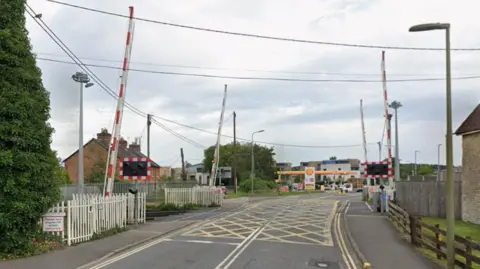 Google A google maps screenshot of the london road rail crossing. It is on a single carriageway, and has four separate barriers, as well as lights. Further down the road is a petrol station.