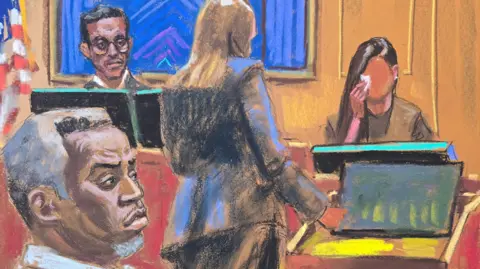 In a courtroom sketch, Sean "Diddy" Combs watches as a prosecutor questions "Jane" during Combs' sex trafficking trial in New York City.