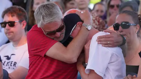 PA Media David and Barnaby's younger brother Charlie at a vigil at the University of Nottingham, following the attacks