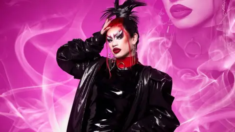 A drag queen wearing shiny, black leather-look clothes with dramatic makeup.