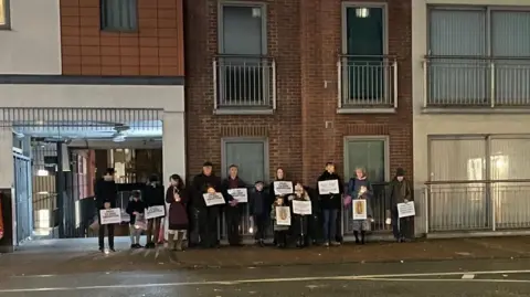 A previous pro-life vigil opposite the BPAS clinic in London Street, Reading (faces pixelized to protect the identities of children). Several people stand holding placards.