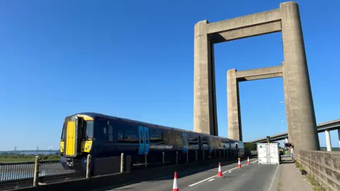 Network Rail A train crossing the Kingsferry Bridge on a sunny day