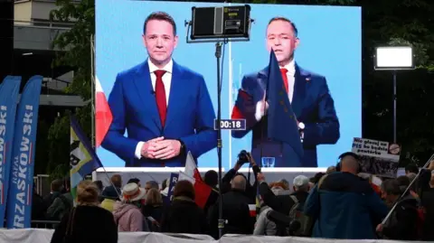 Supporters of Warsaw Mayor Rafal Trzaskowsk watch a final debate with Rafal Trzaskowski and Karol Nawrocki on 23 May