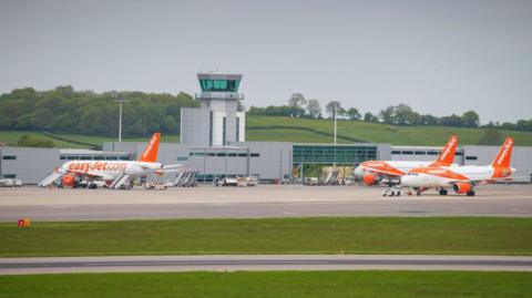 Three easyJet planes in front of the air traffic control tower at Bristol Airport