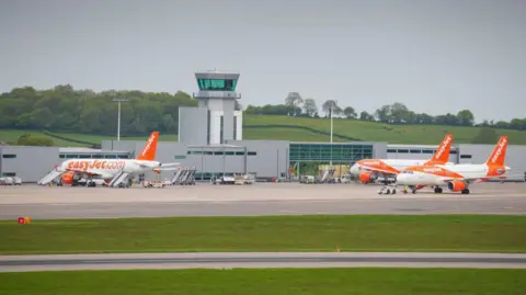 Three easyJet planes in front of the air traffic control tower at Bristol Airport