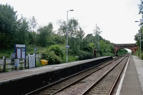 Alamy Elton and Orston platform shows two tracks, a railway bridge and a green platform with lampposts and a small white gate