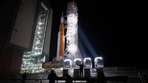 Getty Images NASA's Space Launch System (SLS) rocket and Orion spacecraft, secured to the mobile launcher, is seen as it rolls out of the Vehicle Assembly Building to Launch Pad 39B, Friday, March 20, 2026, at NASA's Kennedy Space Center in Florida.