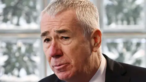 Charles McQuillan/Getty Images A grey haired man looks off camera, his eyebrows are furrowed and his mouth is downturned